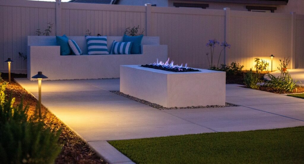 Backyard patio with lights on poles illuminating pathway