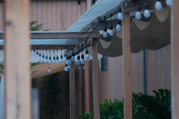 vintage style string lights strung along the edge of a pergola